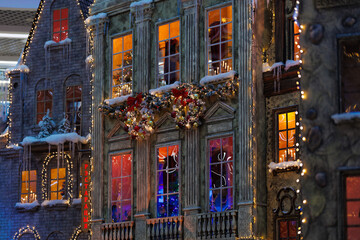New Year's decorations, toys and garlands on the windows in fabulous scenery. Houses for children in a public place. 