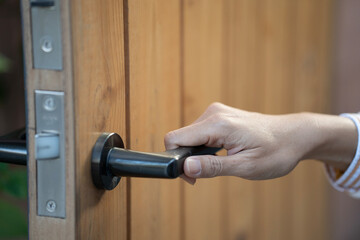 close up of woman hand hold handle of door.