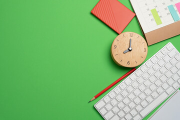 Fototapeta na wymiar close up of workspace desk with notebook, laptop or computer keyboard with copy space green table background, minimal style, for creative flat lay concept