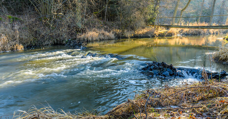 cascades on small river with wooden bridge