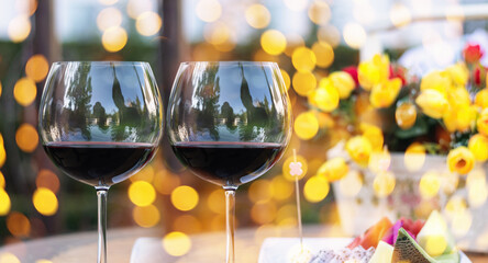 A glass of red wine on table with blur light in restaurant.