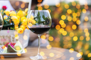 A glass of red wine on table with blur light in restaurant.