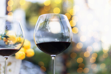 A glass of red wine on table with blur light in restaurant.