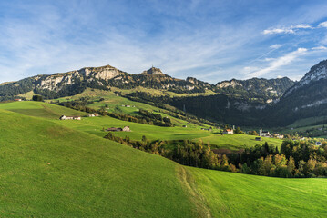 Fototapeta na wymiar Appenzellerland, landscape with farms and green meadows, view of the Hoher Kasten and the village of Bruelisau in the Alpstein mountains, Canton Appenzell Innerrhoden, Switzerland