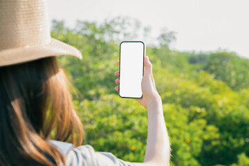 Young woman traveling hand holding smartphone with taking photo on garden, Take your screen to put...