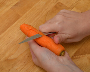 Apetyczna zdrowa marchewka obierania nożem  - obrazy, fototapety, plakaty