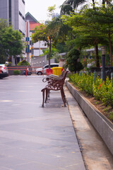 sitting benches on the sidewalk by the side of the road