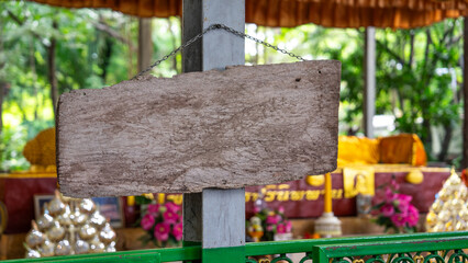 Image of a medium sized notice board Made from natural wood It is cut into rectangular sheets. There is a chain attached to the back. and was hung on a cement pole with nails driven into it - obrazy, fototapety, plakaty