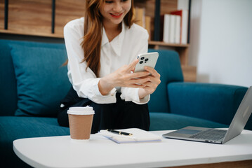 woman using the smartphone and tablet on the sofa at home