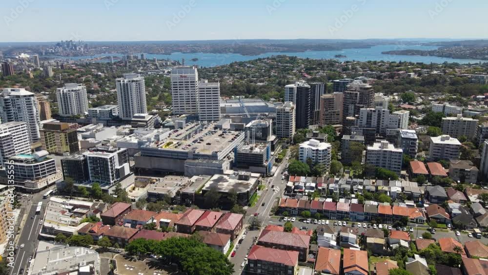 Wall mural Aerial drone pullback reverse view of Bondi Junction in the Eastern Suburbs of Sydney, NSW Australia with Sydney City in the background on a sunny day