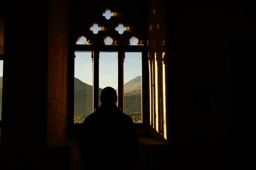 Silouette of a man looking at the mountains outside Celano Castle, L'Aquila, Abruzzo, Italy
