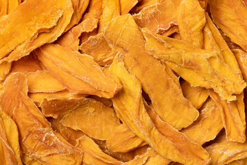Healthy dried mango chips without added sugar close up full frame as background  