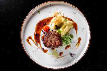 Grilled beef steak filet mignon with potato and sauce in plate