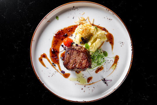Grilled beef steak filet mignon with potato and sauce in plate