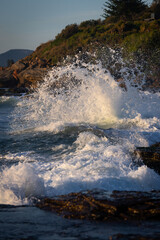 Big wave crashing into the rocky coast.