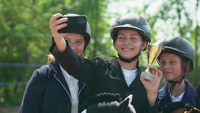 teenagers take selfies on smartphones. children take pictures. girls rejoice at winning the competition. Horseback riding. Horseback Riding. Slow motion video. High quality FullHD footage
