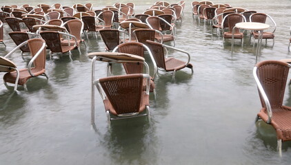 High tide in Venice Island in Italy chairs and tables of the alfresco cafe