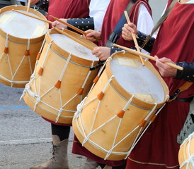 Fototapeta na wymiar drum players with medieval clothes and ancient instruments during the historical re-enactment through the streets