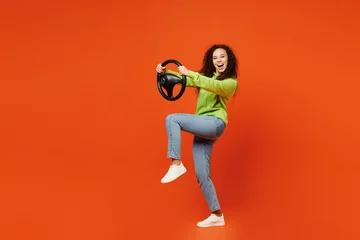 Foto op Plexiglas Graffiti collage Full body side profile view young woman of African American ethnicity she wears green hoody casual clothes hold steering wheel driving car isolated on plain red orange background. Lifestyle concept.