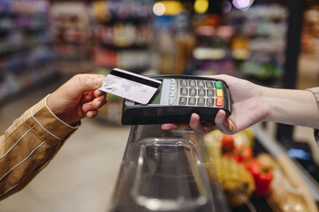 Close up cropped photo customer holding wireless bank payment terminal process acquire credit card...