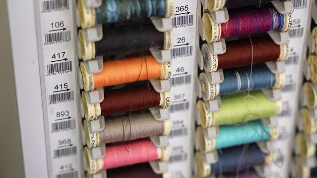 High quality numbered colourful cotton thread bobbins in professional tailor atelier, wide collection of fabric thread reels for embroidery or clothes repair in dressmaker workshop. Needlecraft