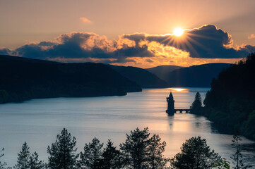 Lake Vyrnwy, located in mid Wales, an area of outstanding natural beauty, at sunset. The orange sky...