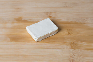 A whole cube of white processed cheese.