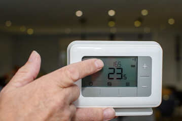 Central heating thermostat control panel. Handheld device used to control the temperature in the...