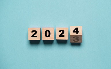 Flipping of 2023 to 2024 on wooden block cube for preparation new year change and start new business target strategy concept.