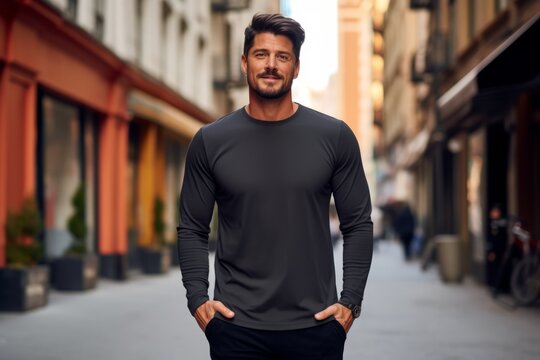 A stylish black blank longsleeve t-shirt for mock up, worn by a fashionable model in an urban setting. Empty space for logo or design on the front of the t-shirt