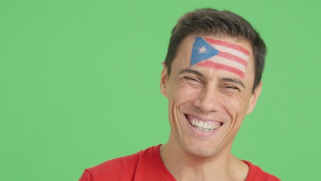 Man with a puerto rican flag painted on the face smiling