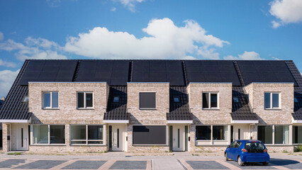 Newly built houses with solar panels attached on the roof against a sunny sky, Close up of new...