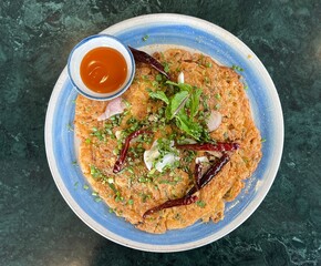 Top view table crispy larb omelet with dried chili and ketchup.