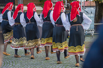 People dressed with traditional Bulgarian authentic folklore clothes dancing folk dance - obrazy, fototapety, plakaty