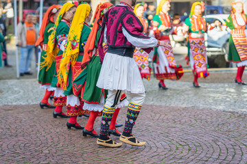 Abstract girls dancing folk dance. People in traditional costumes dance Bulgarian folk dances