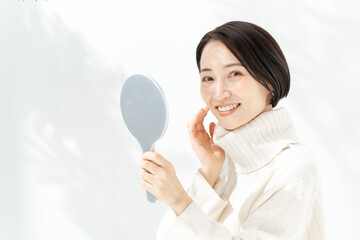 手鏡で肌を確認する女性
