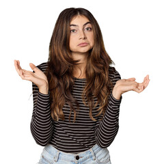 Young Caucasian woman in studio setting doubting and shrugging shoulders in questioning gesture.