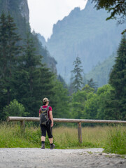 Fototapeta na wymiar hiking on a gravel path as a woman walks closer to a mountain valley