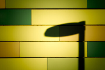 Schatten einer Laterne vor gelber Fassade