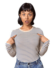 Young Hispanic woman with short black hair in studio surprised pointing with finger, smiling...