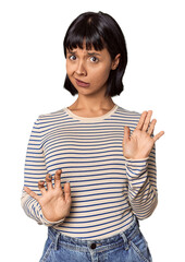 Young Hispanic woman with short black hair in studio rejecting someone showing a gesture of disgust.