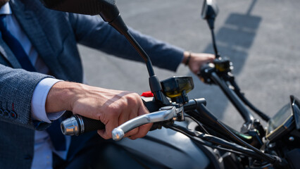 Caucasian man rides an electric motorcycle. Close-up of male hands on the steering wheel. 