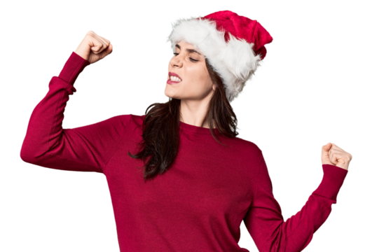 Young woman in Santa hat and red sweater raising fist after a victory, winner concept.