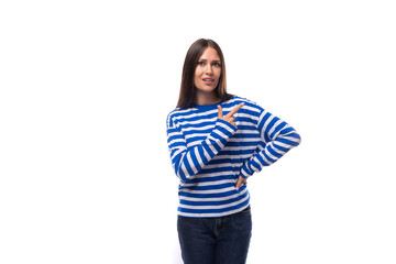 young slender brunette lady with straight hair dressed casually demonstrates space on the wall for advertising