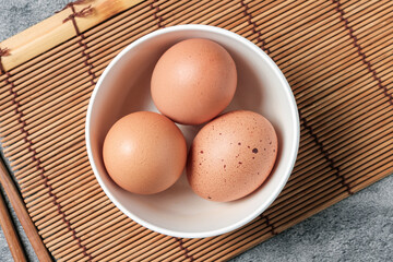 Chicken eggs in a white cup, to prepare for breakfast, nutrition concept.