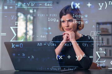 Pensive attractive beautiful businesswoman in studying on laptop at university library in...