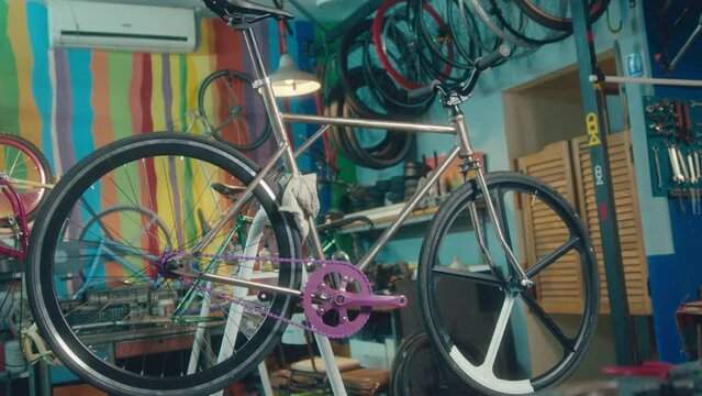 New custom bike with purple chainset on repair rack in the workshop with no people