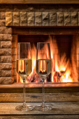 In front of the fireplace on a winter evening, glasses of champagne wine.