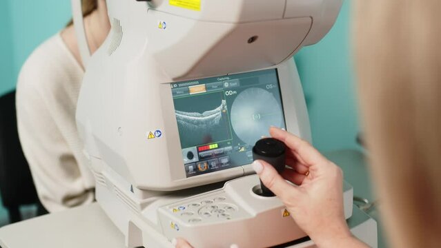 A female ophthalmologist performs a retinal examination using optical coherence tomography (OCT). The concept of medical vision diagnostics or vision correction.