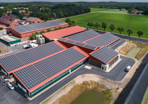 Moderne Tierhaltungsst&auml;lle mit gro&szlig;fl&auml;chig auf den D&auml;chern montierte Photovoltaikanlagen zur nachhaltigen Energieerzeugung. Luftbild - Symbolfoto.